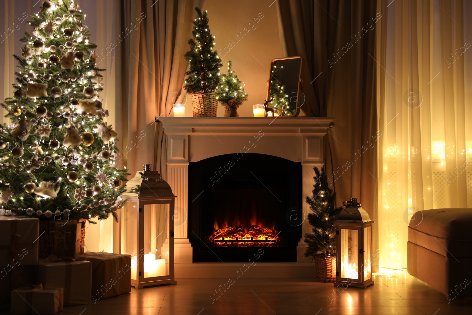 Photo of Beautiful fireplace, Christmas tree and other decorations in living room at night. Interior design