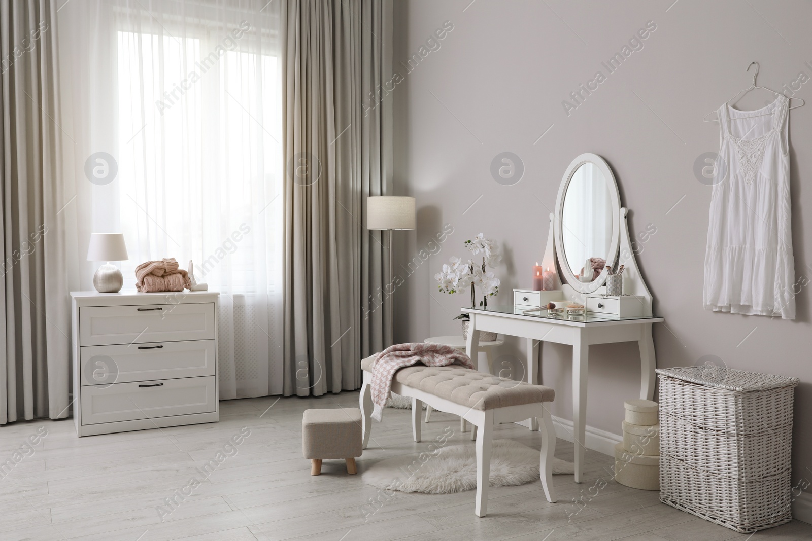 Photo of Wooden dressing table with decorative elements and makeup products in room. Interior design