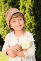 Cute little girl with chick outdoors. Baby animal