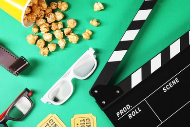 Photo of Flat lay composition with clapperboard, movie tickets and 3D glasses on green background