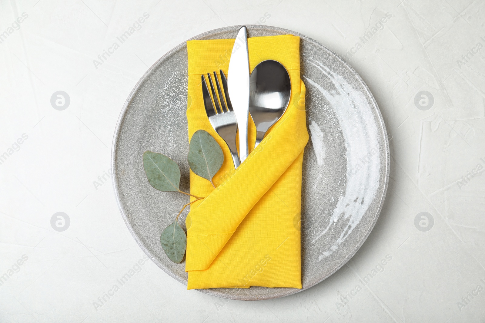 Photo of Plate with cutlery and napkin on light background, top view