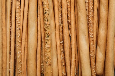 Photo of Delicious grissini sticks as background, top view