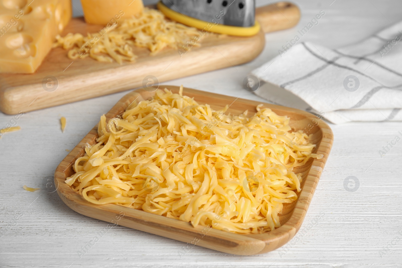 Photo of Delicious grated cheese on white wooden table