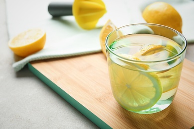 Photo of Glass of water with lemon slice on wooden board