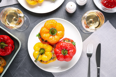 Photo of Tasty stuffed bell peppers served on grey table, flat lay