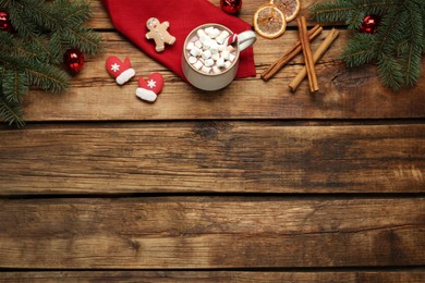 Photo of Flat lay composition of delicious hot chocolate with marshmallows and Christmas decor on wooden table, space for text