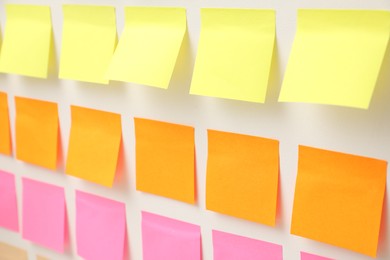 Photo of Blank colorful paper notes on white board, closeup