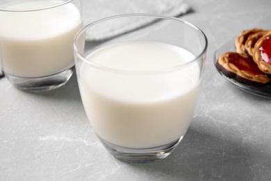 Photo of Glass of delicious milk on grey table