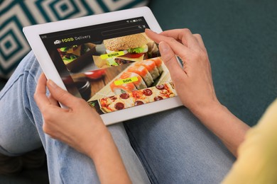 Photo of Woman using tablet for ordering food online at home, closeup. Concept of delivery service