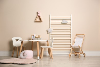 Photo of Baby room interior with stylish table, chairs and toys