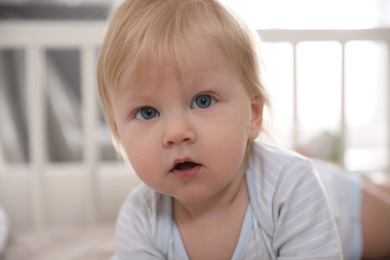 Photo of Adorable little baby on blurred background, closeup