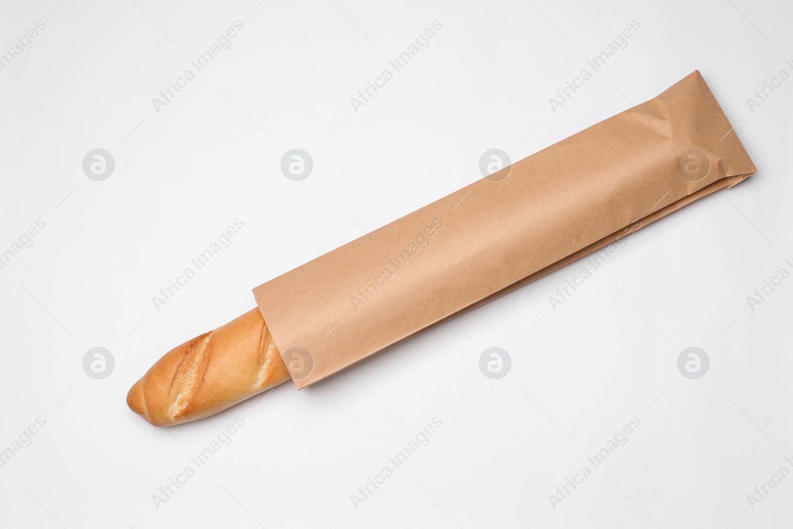 Photo of Paper bag with bread on white background, top view. Space for design