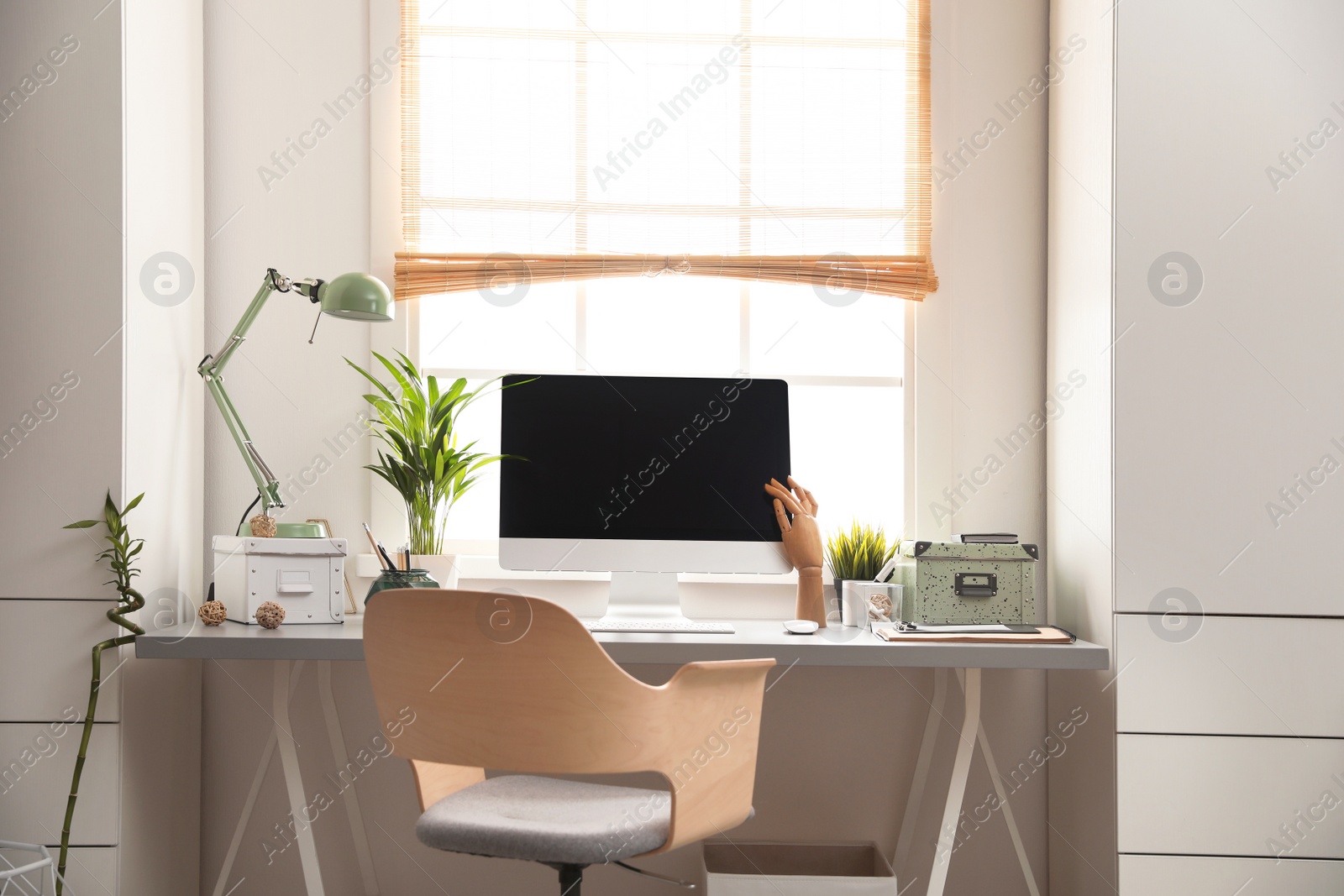 Photo of Light work place with computer near window at home. Interior design