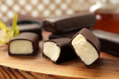 Photo of Glazed curd cheese bars on wooden board, closeup