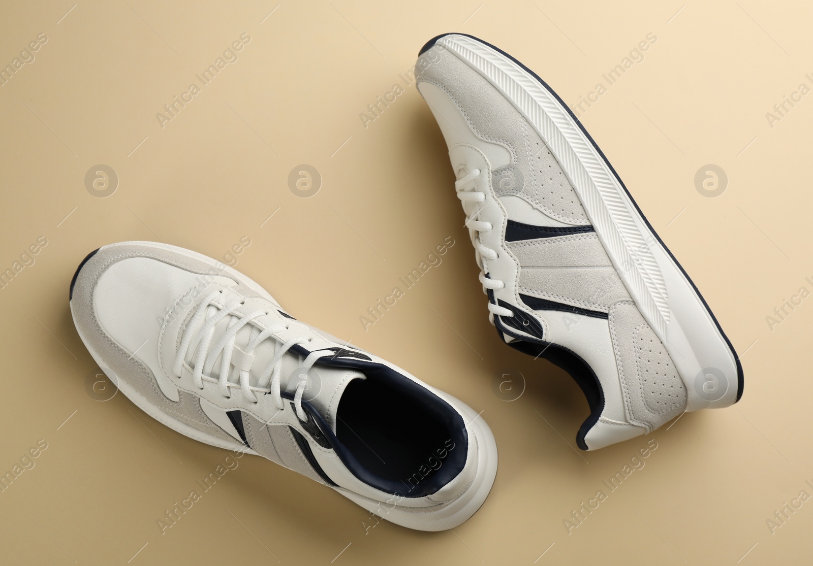 Photo of Pair of stylish sports shoes on beige background, flat lay