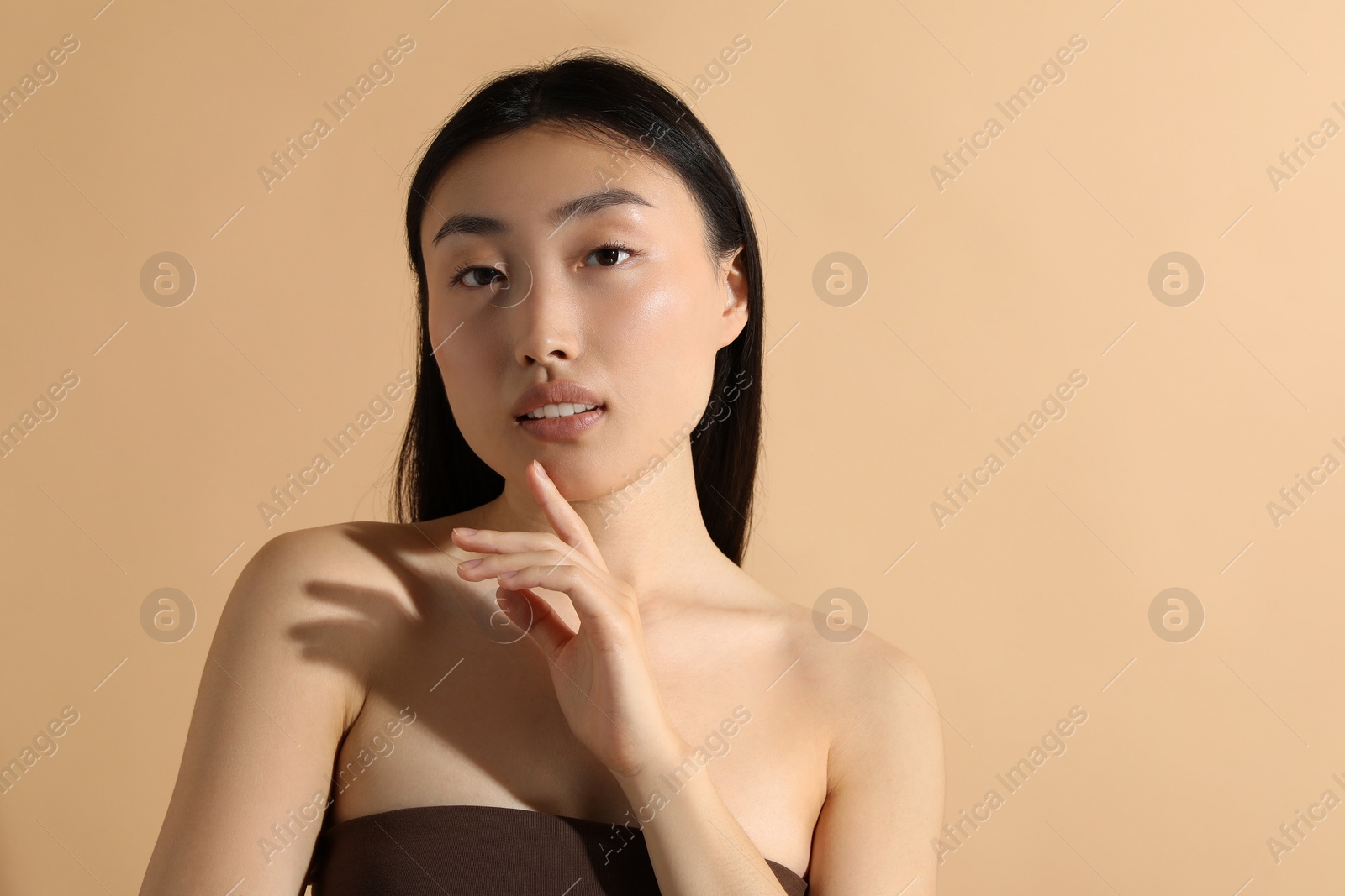 Photo of Beautiful young woman on beige background, space for text