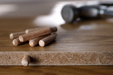 Photo of Wooden furniture parts and pile of dowels, closeup. Self-assembly