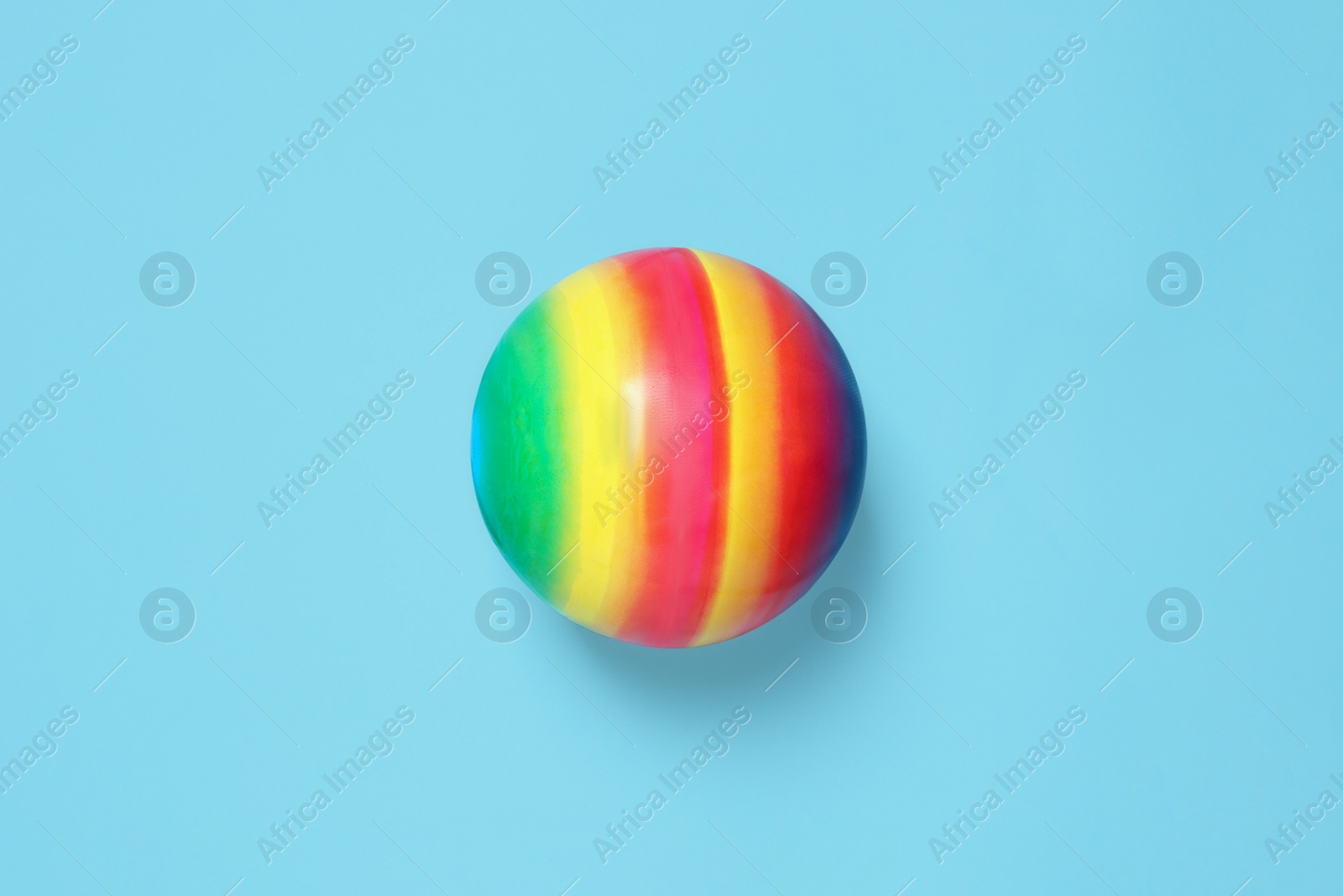 Photo of New bright kids' ball on light blue background, top view