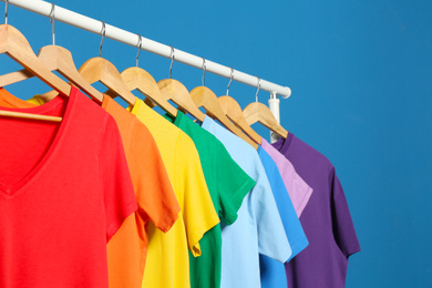 Photo of Bright clothes on blue background. Rainbow colors