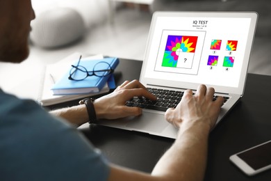 Man using laptop for taking IQ test indoors, closeup