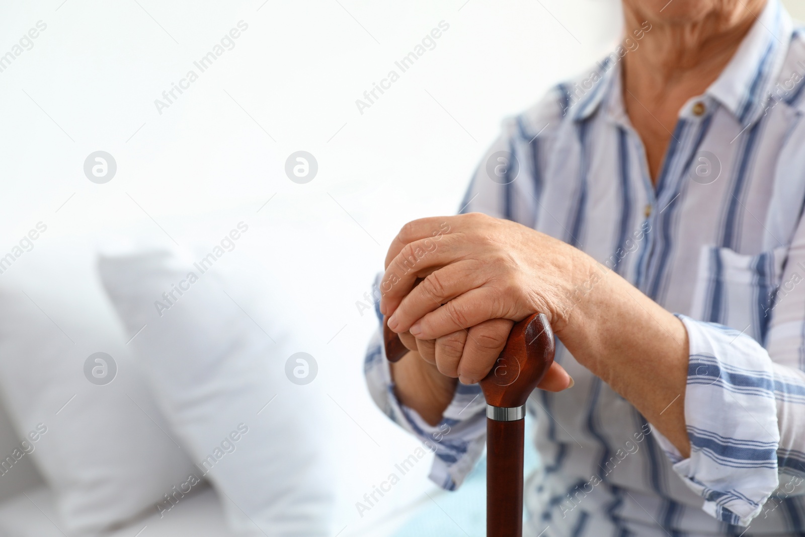 Photo of Elderly woman with walking cane in nursing home, closeup. Medical assistance
