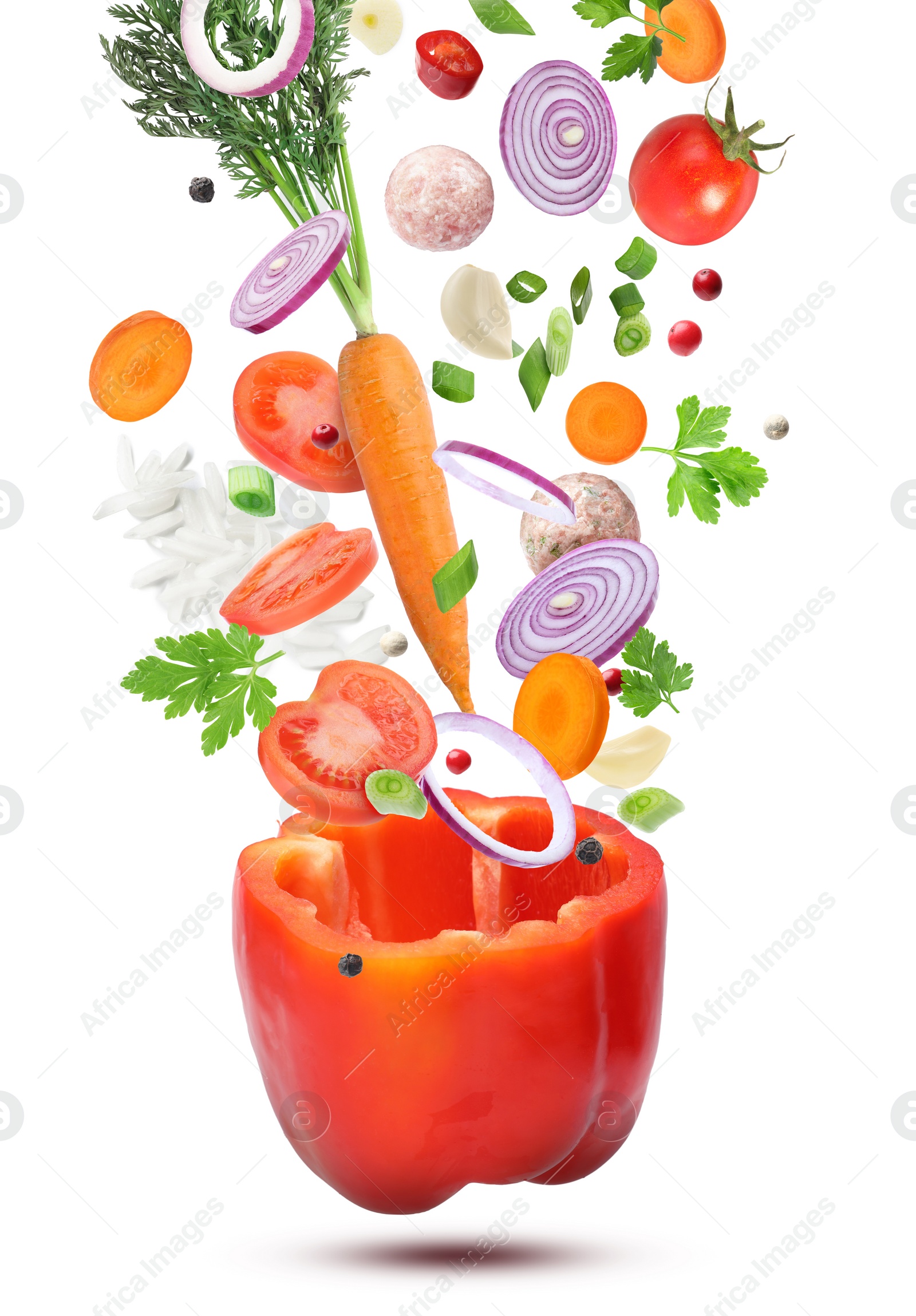 Image of Stuffed pepper recipe. Fresh ingredients falling into bell pepper on white background