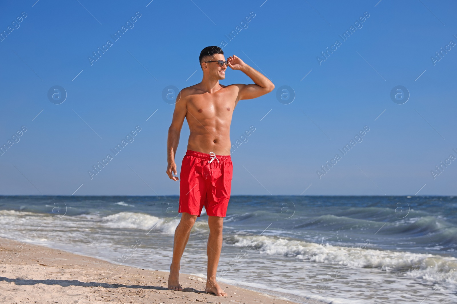 Photo of Handsome man with attractive body on beach