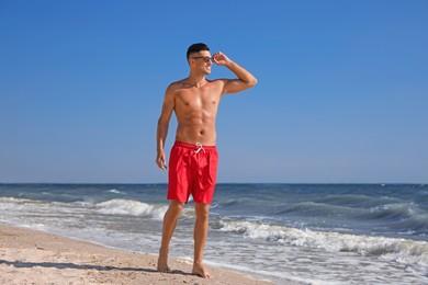 Photo of Handsome man with attractive body on beach