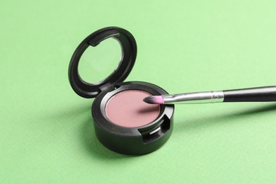 Photo of Eye shadow and brush on color background. Decorative cosmetics