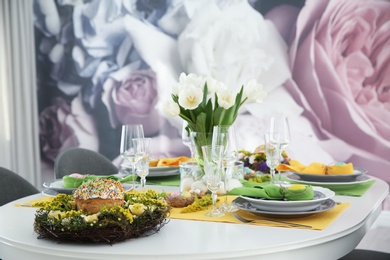 Photo of Festive Easter table setting with beautiful white tulips and eggs indoors