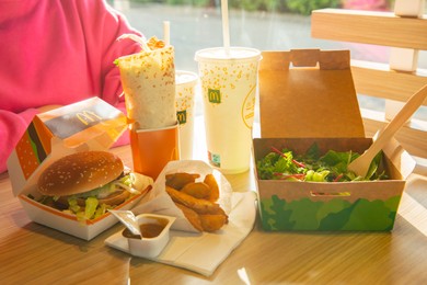 Photo of WARSAW, POLAND - SEPTEMBER 16, 2022: Big Mac hamburger, fried potatoes and cold drinks on table in McDonald's cafe