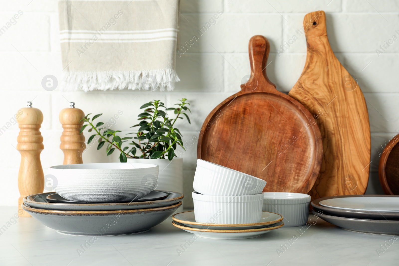 Photo of Set of clean tableware on white countertop in kitchen