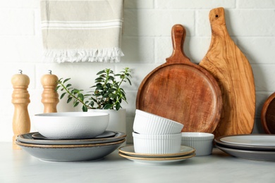 Photo of Set of clean tableware on white countertop in kitchen