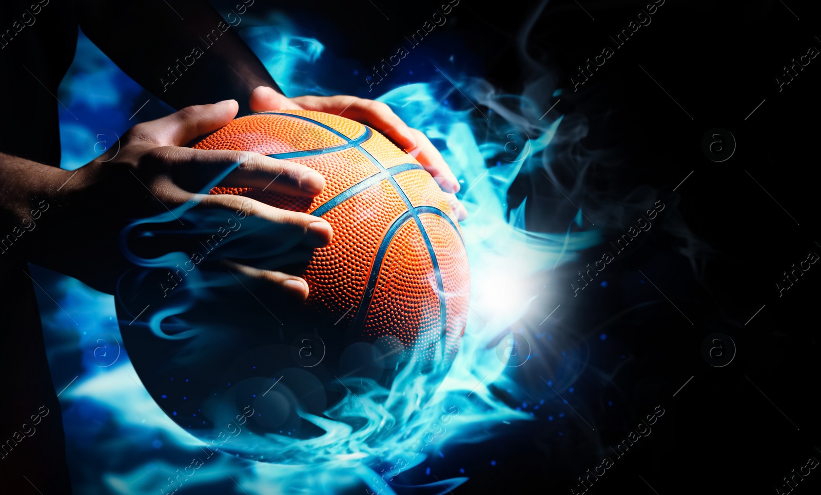 Image of Basketball player with ball in flame on black background, closeup 