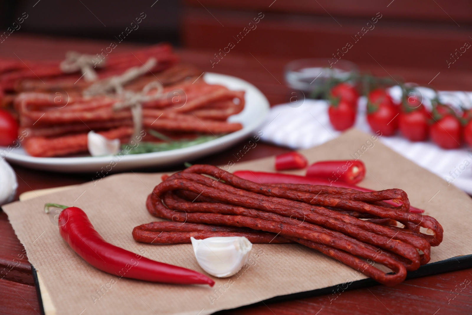 Photo of Delicious kabanosy with garlic and chilli on wooden table