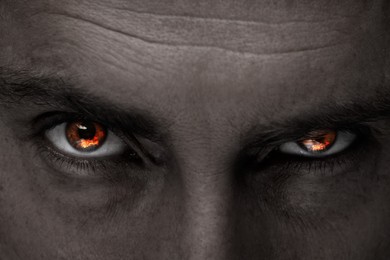 Image of Man with fire burning in his eyes, closeup. Evil eye