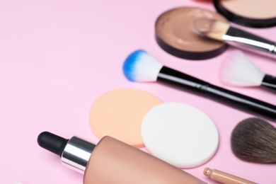 Photo of Composition with skin foundation and beauty accessories on color background