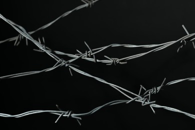 Photo of Shiny metal barbed wire on black background