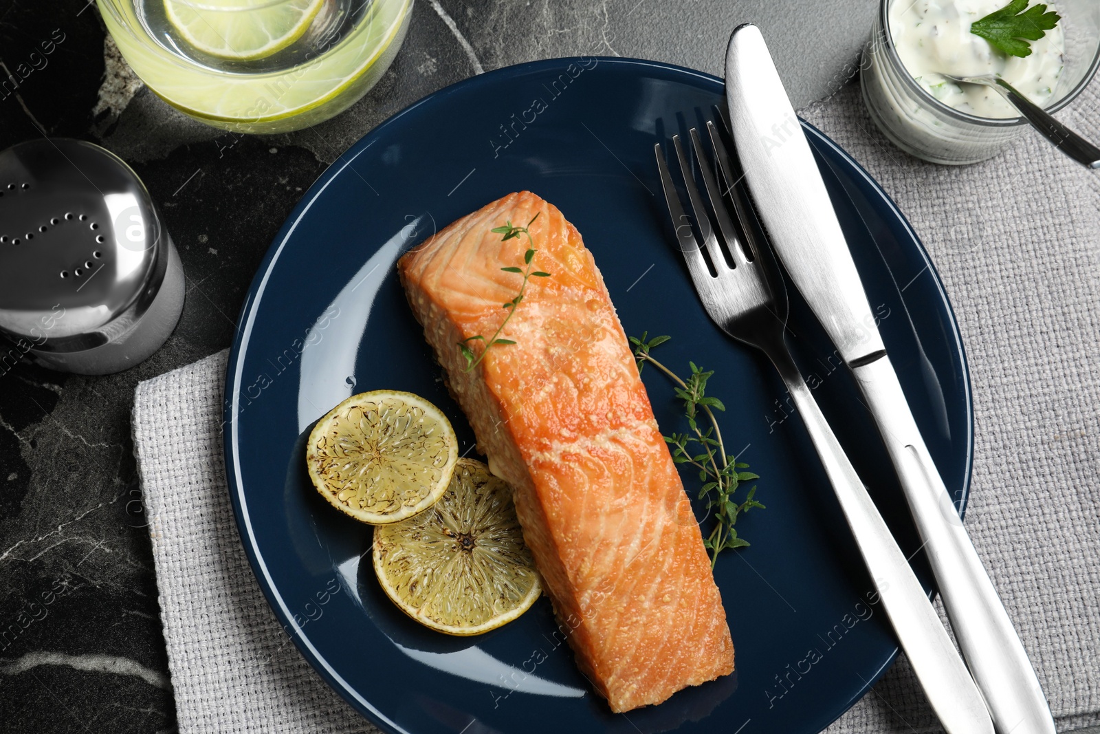 Photo of Flat lay composition with cooked red fish on dark marble table