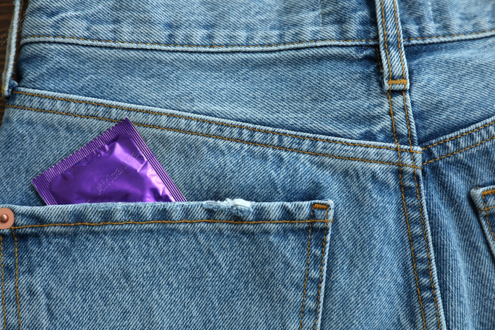 Photo of Closeup view of jeans with condom in pocket. Safe sex concept