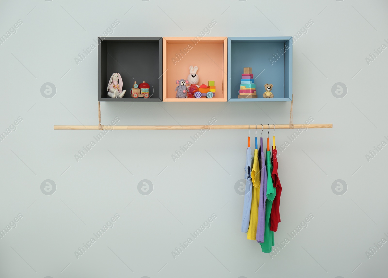 Photo of Rack with different clothes on light background