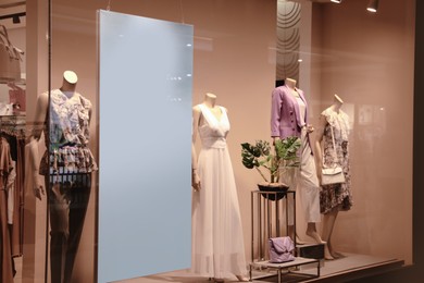 Photo of Beautiful clothes on mannequins in showcases of fashion store