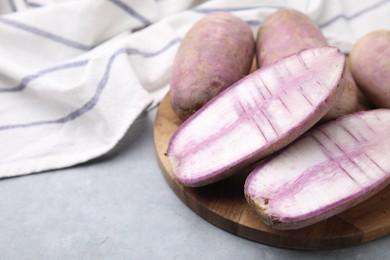 Photo of Purple daikon radishes on light grey table, closeup. Space for text