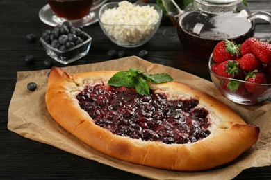 Delicious sweet cottage cheese pastry with cherry jam served on wooden table