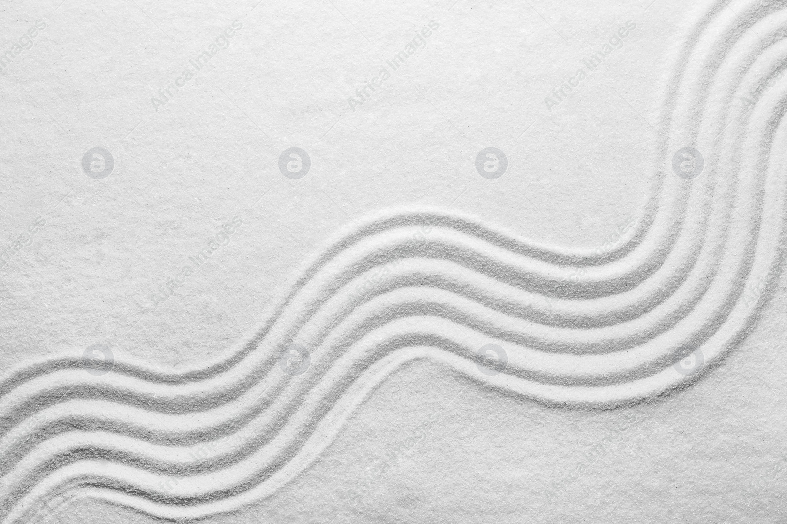 Photo of White sand with pattern as background, top view. Zen, meditation, harmony