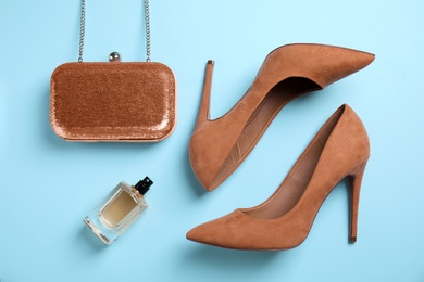 Photo of Beautiful shoes, bottle of perfume and small bag on color background, top view