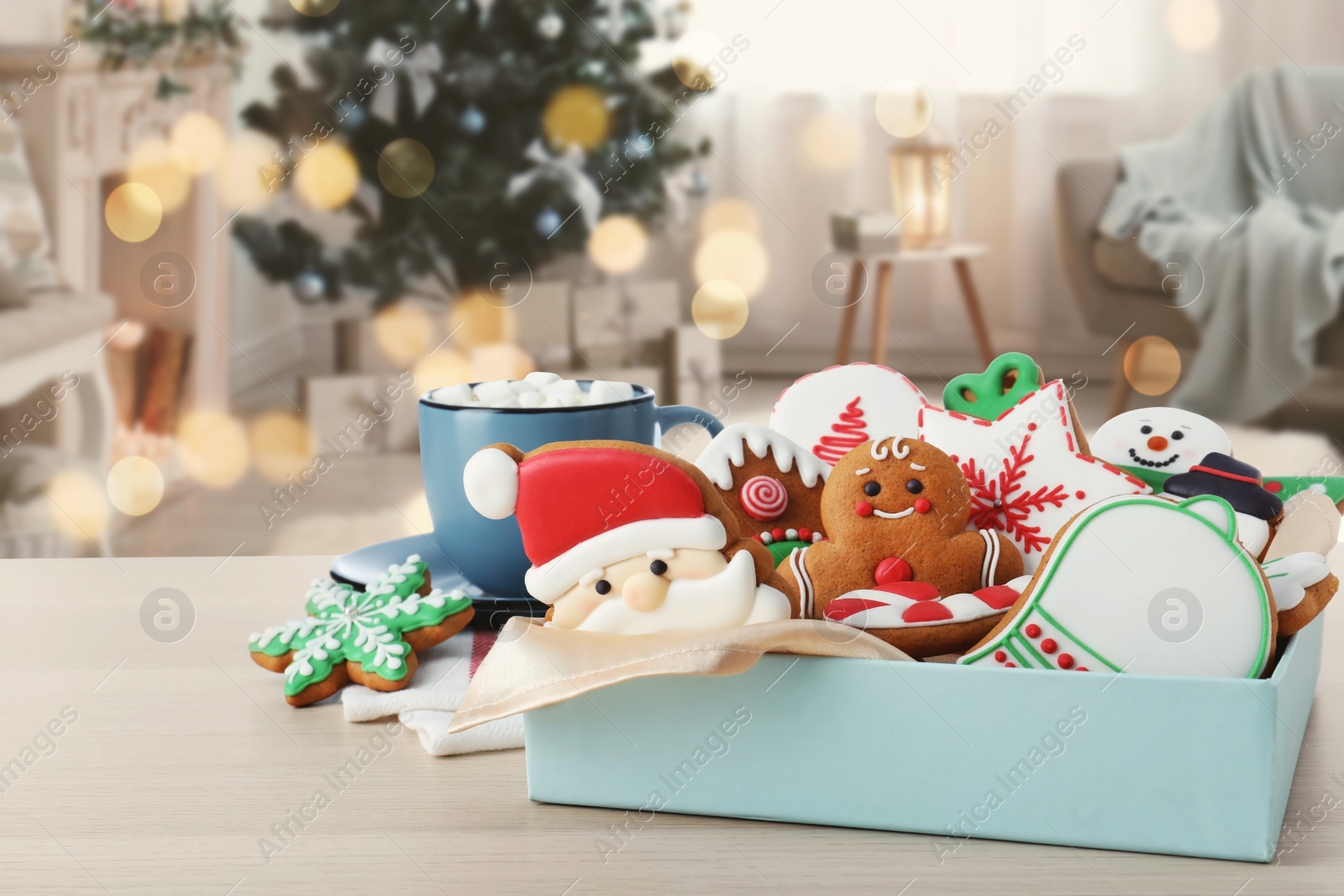 Image of Christmas cookies and cup of hot drink on table in decorated room 