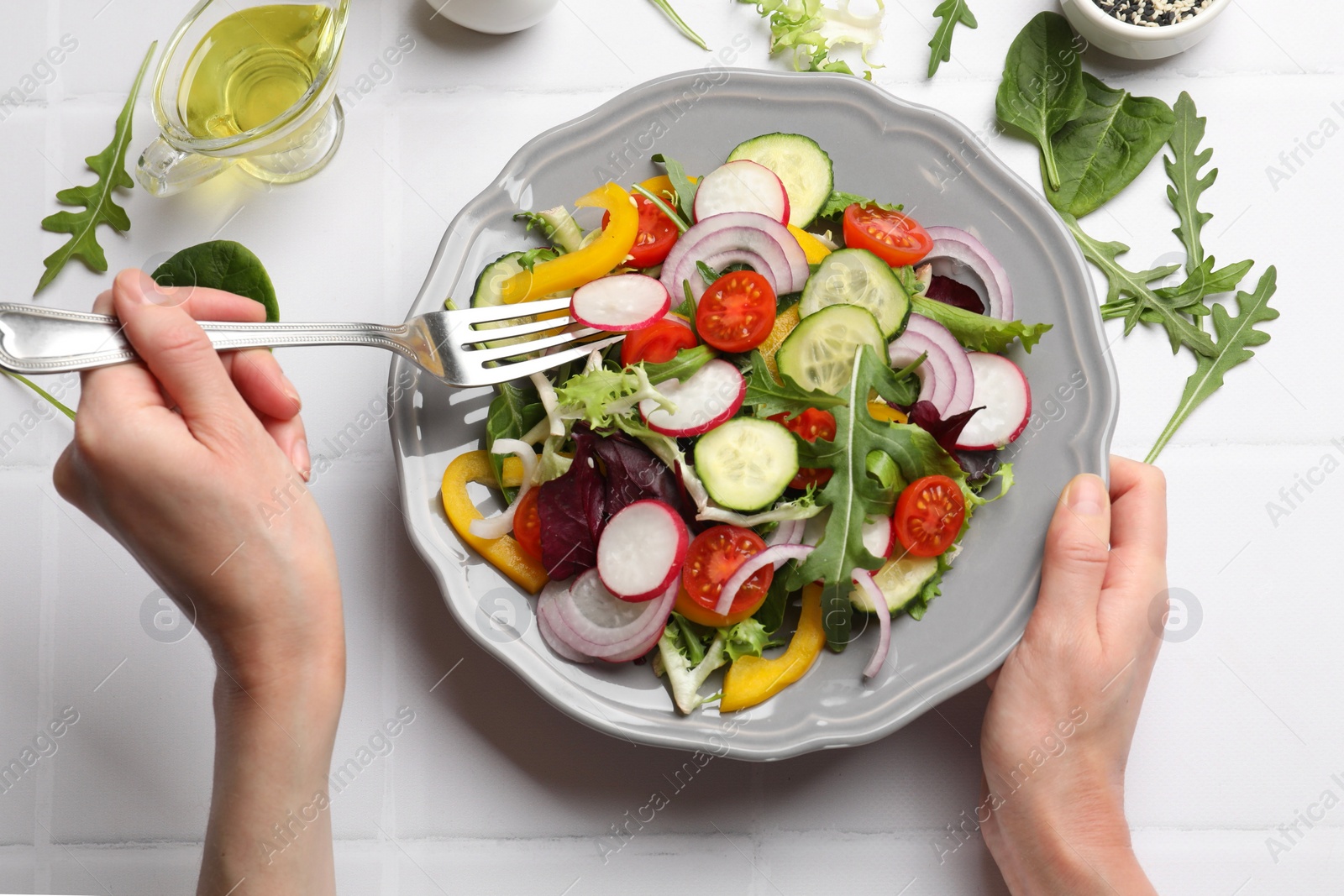 Photo of Balanced diet and vegetarian foods. Woman eating dinner at white table, top view