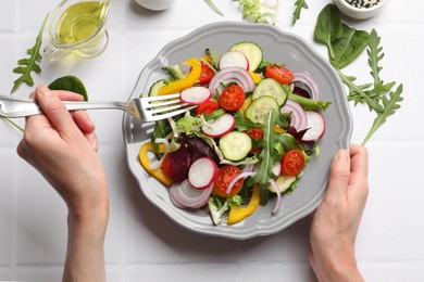 Photo of Balanced diet and vegetarian foods. Woman eating dinner at white table, top view