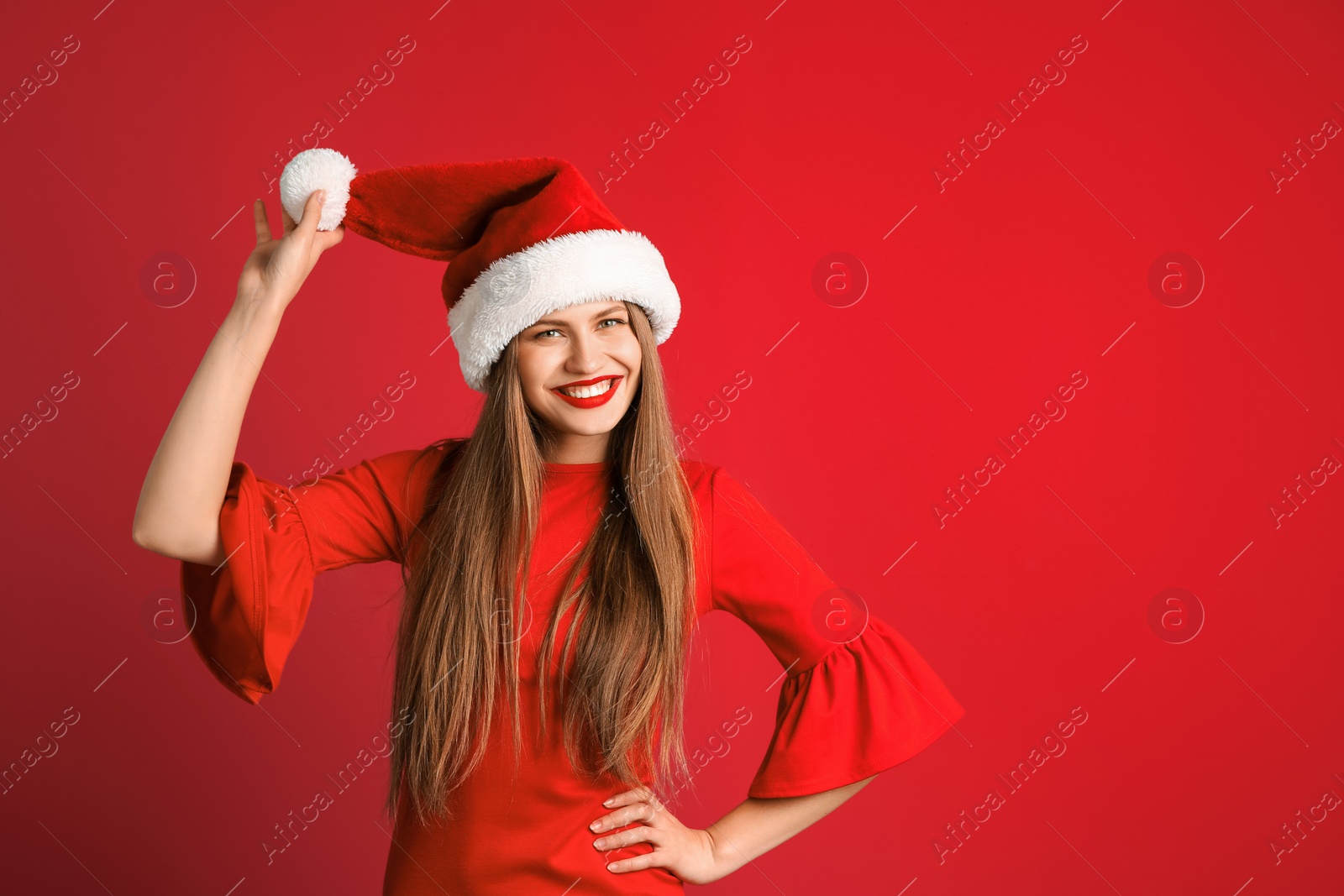 Photo of Young beautiful woman in Santa hat on color background. Christmas celebration